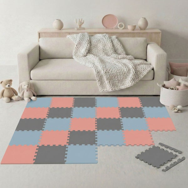 Mehrfarbige Puzzlespielmatte aus Schaumstoff in einem hellen Wohnzimmer vor einem Sofa mit Kuscheltieren und Dekoration.