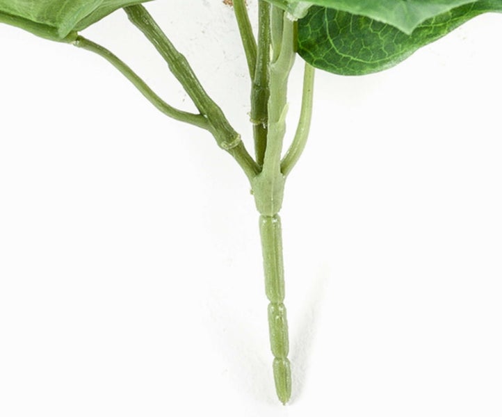 Künstlicher Monstera-Zweig aus Kunststoff mit charakteristisch gelochten grünen Blättern.