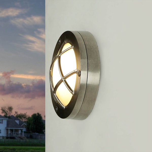 Runde Außenleuchte mit Schutzgitter an einer Wand