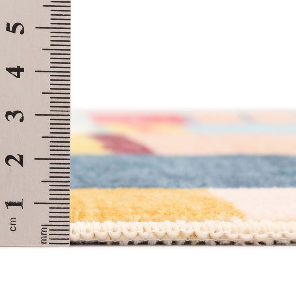 Nahaufnahme der Florhöhe eines Teppichs an einem Lineal, circa 1 Zentimeter hoch.