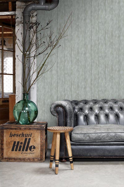 Wohnraum mit Vintage-Sofa, Holzhocker, Dekoration und Tapete
