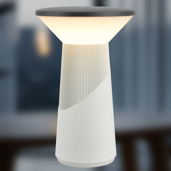 Moderne LED-Tischleuchte aus Kunststoff, weiß mit dunkelgrauer Oberseite, geriffelter Fuß, eingeschaltet.