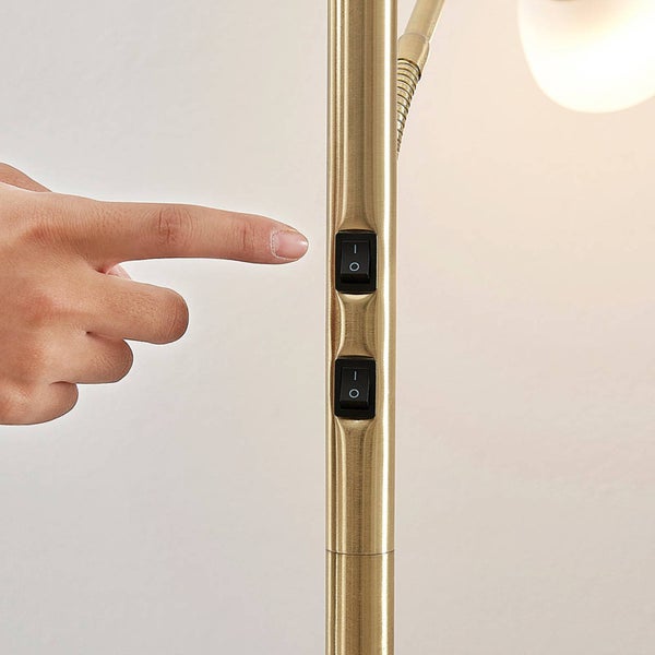 Nahaufnahme eines Fingers, der einen Schalter an einer Stehlampe betätigt.