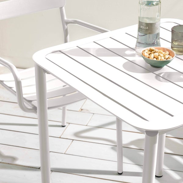 Modernes Gartenmöbel-Set aus weißem Metall mit rechteckigem Tisch in Lattenoptik und passendem Armlehnstuhl auf einer hellen Holzterrasse.