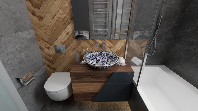 Helles Badezimmer mit Toilette, Waschbecken mit blauem Muster und Badewanne