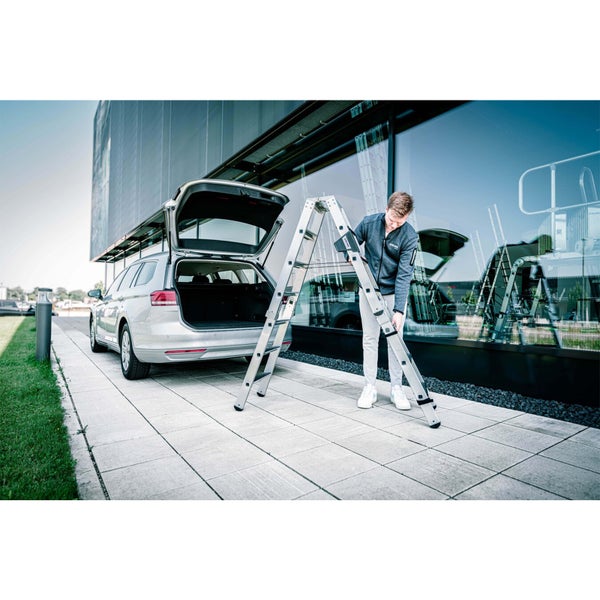 Mann baut Mehrzweckleiter am Auto auf