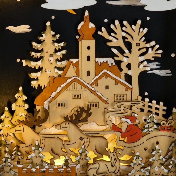 Weihnachtliche Holzdekoration mit beleuchteter Winterszene aus einem Dorf mit Kirche, verschneiten Tannen und dem Weihnachtsmann im Rentierschlitten.