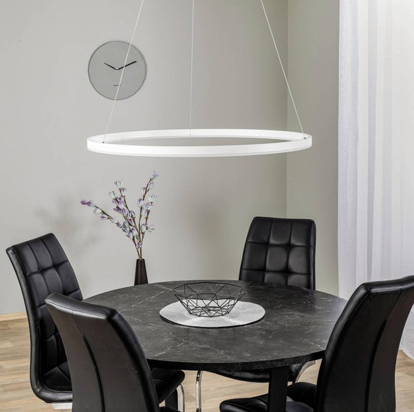 Moderne Pendelleuchte in Ringform über einem runden Esstisch mit schwarzen Stühlen und Marmor Optik.