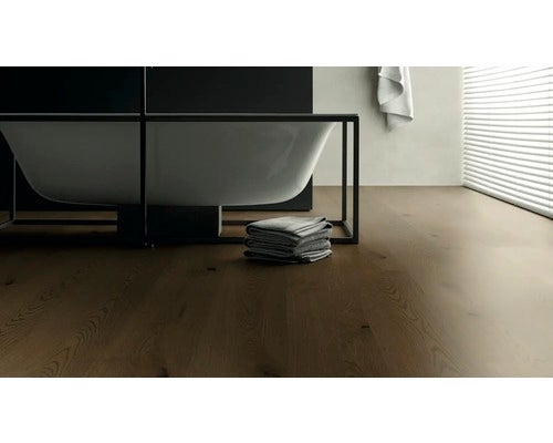 Badezimmer mit freistehender Badewanne und Holzboden