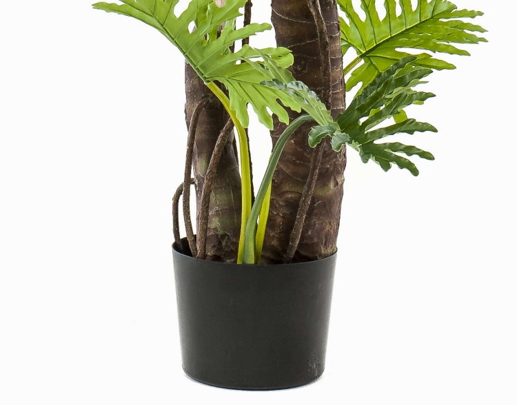 Künstlicher Philodendron mit grünen gelappten Blättern und strukturierten Stämmen in einem schwarzen Kunststofftopf.