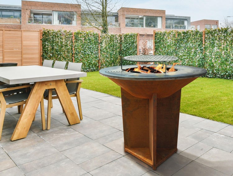 Außenaufnahme eines Gartens mit einem Esstisch und einem Grill