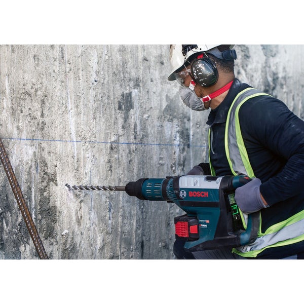 Ein Bauarbeiter bohrt mit einem Bosch Bohrhammer ein Loch in eine Betonwand