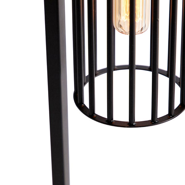 Detailaufnahme einer Stehlampe mit einem Lampenschirm aus Metallgittern und einer Glühbirne