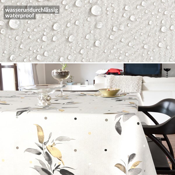 Wasserundurchlässige Tischdecke mit Blattmuster und Punkten in einem modernen Wohnzimmer. Detailansicht zeigt die wasserabweisende Oberfläche.