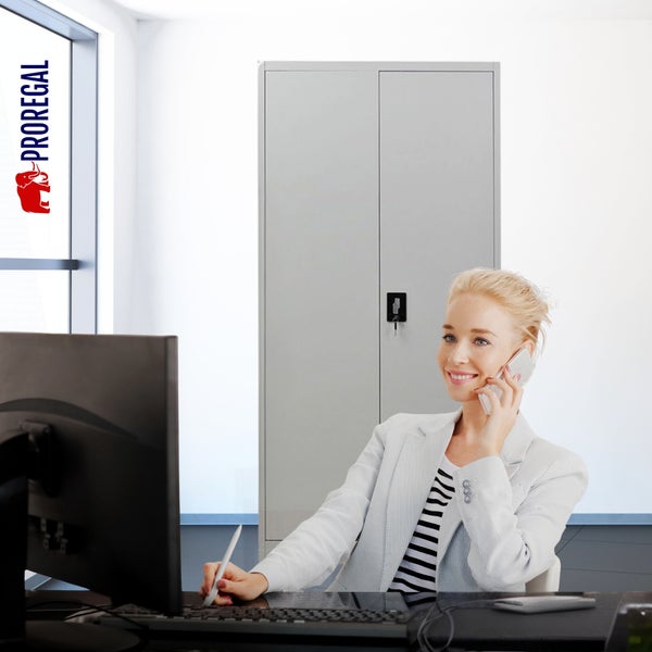 Proregal Metall-Büroschrank in einem modernen, hellen Büro mit einer am Schreibtisch arbeitenden Frau.