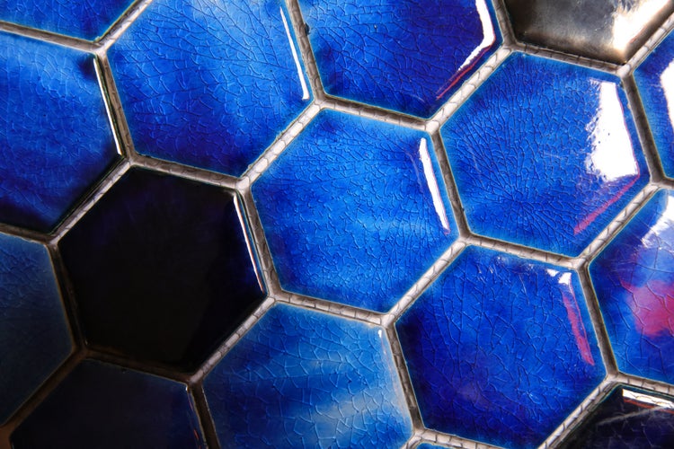 Nahaufnahme von sechseckigen Fliesen mit gesprenkelter Glasur