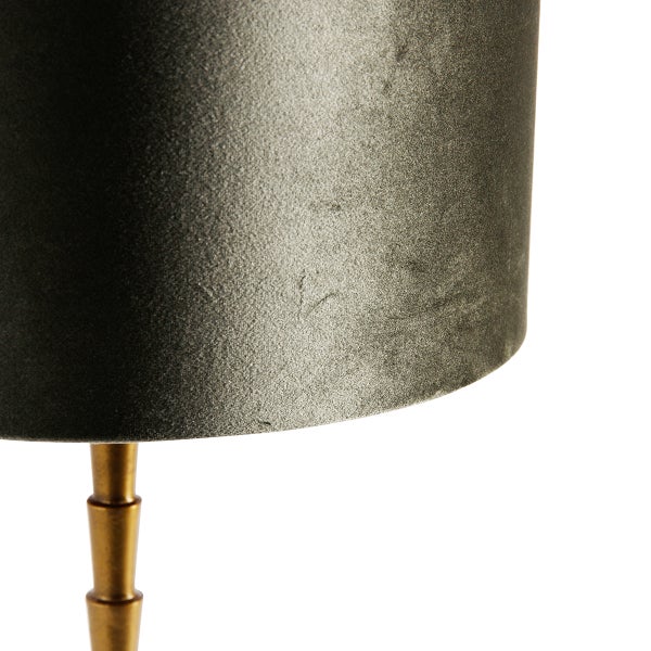 Nahaufnahme eines Lampenschirms aus Samt mit goldenem Lampenfuß.