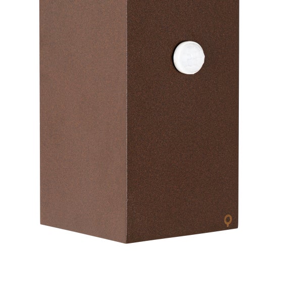 Detailansicht eines Bewegungsmelders an einer rostfarbenen Außenleuchte.