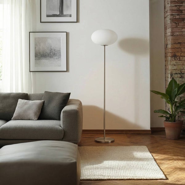 Wohnzimmer mit grauem Sofa, Teppich und Stehlampe mit kugelförmigem Schirm