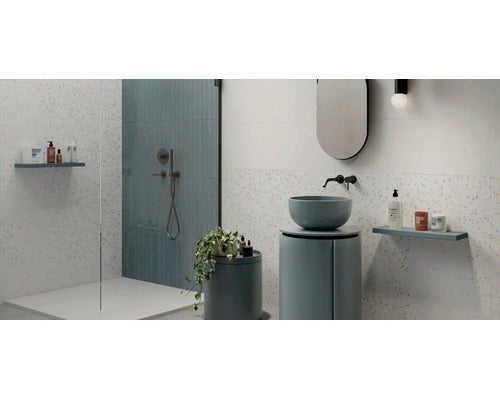 Modernes Badezimmer mit begehbarer Dusche, rundem Aufsatzwaschbecken auf einem zylindrischen Unterschrank und Wänden in Terrazzo-Optik.