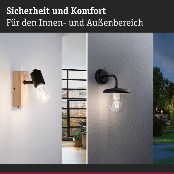 Wandleuchte aus Holz für den Innenbereich und schwarze Außenwandleuchte für den Außenbereich, beide eingeschaltet zur Beleuchtung.