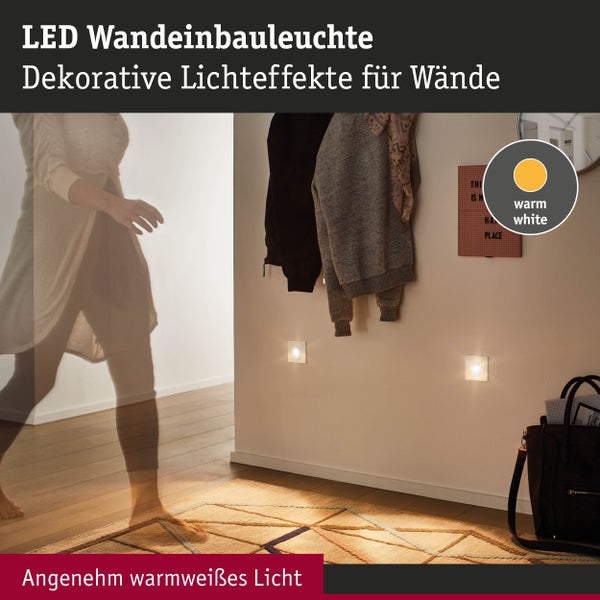 LED-Wandeinbauleuchten mit warmweißem Licht in einem hellen Flur mit weißer Wand, Holzfußboden und Teppich.