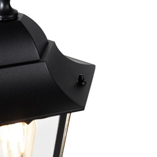 Nahaufnahme einer schwarzen Außenleuchte im klassischen Design mit strukturierter Oberfläche und Glaseinsatz.