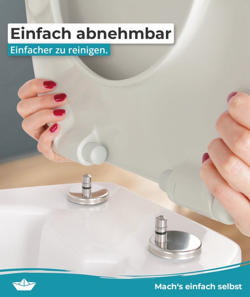 Ein abnehmbarer WC Sitz zur einfacheren Reinigung über dem WC Becken mit Metallbefestigung.
