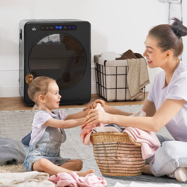 Mutter und Tochter sitzen mit einem tragbaren Wäschetrockner und Wäschekörben auf dem Boden.