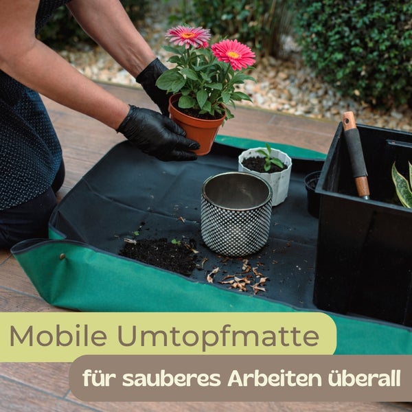 Eine Person nutzt eine mobile Umtopfmatte für das saubere Umtopfen einer blóhenden Pflanze auf einer Terrasse.