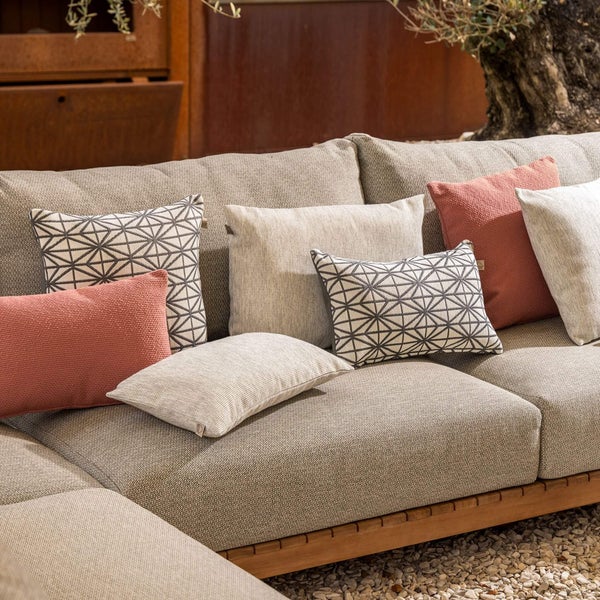 Outdoor-Lounge-Sofa mit grauen Polstern und verschiedenen Zierkissen in Terracotta, Creme und mit geometrischem Muster