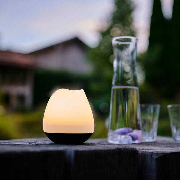 Dekorative Lampe und Wasserkaraffe auf einem Holztisch