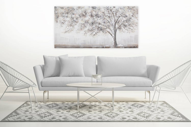 Wohnzimmer mit Sofa, Teppich und Wandbild mit Baum