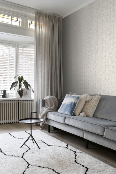 Wohnzimmer mit Sofa, Vorhängen, Teppich und dekorativer Tapete für ein gemütliches Ambiente