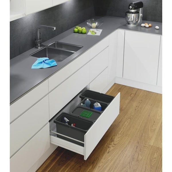 Mülltrennsystem in einer Küchenschublade mit drei Behältern unter einer Spüle in einer modernen, hellen Küche mit Holzfußboden.