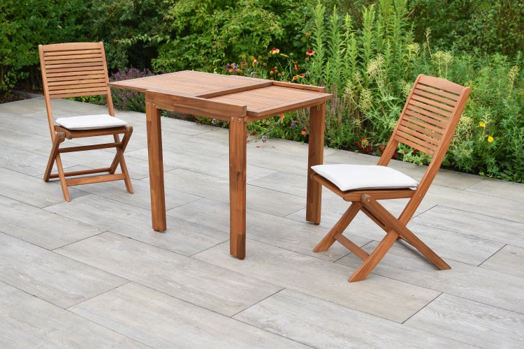 Holz Gartentisch mit zwei Klappstühlen und Sitzkissen auf einer Terrasse