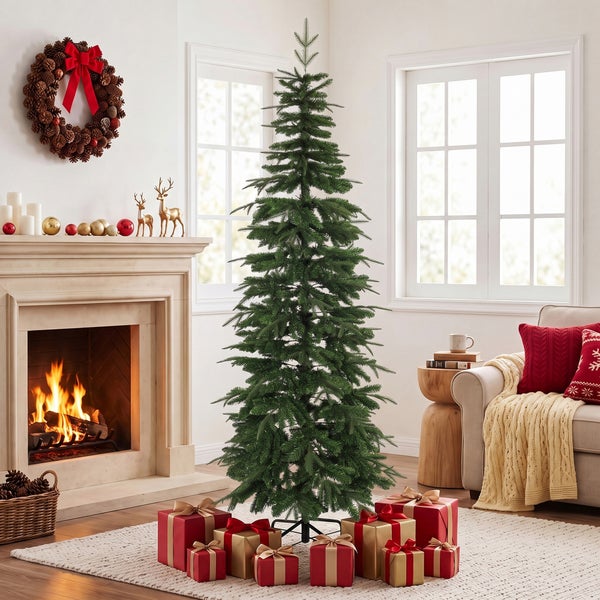 Ein künstlicher Weihnachtsbaum steht in einem geschmückten Wohnzimmer vor einem Kamin mit brennendem Feuer und Weihnachtsgeschenken.