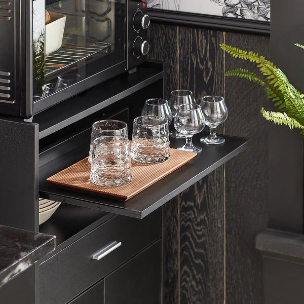 Gläser auf einem Tablett in einer Küchenzeile mit eingebautem Ofen.