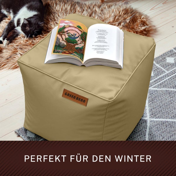 Gemütliche Szene mit einem Buch auf einem Sitzwürfel und einer schlafenden Katze im Hintergrund