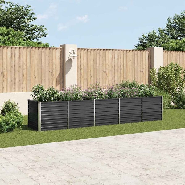 Langes Hochbeet aus Metall mit Wellprofil, bepflanzt mit Blumen in einem gepflegten Garten vor einem Holzzaun.