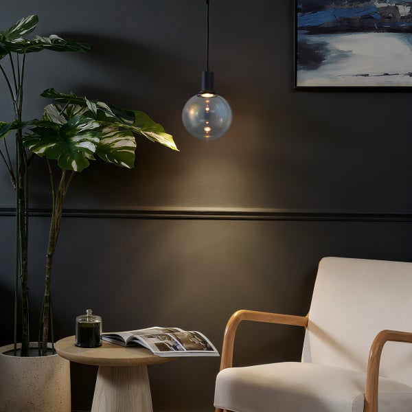 Wohnzimmer Szene mit Hängelampe, Pflanze, Beistelltisch und Sessel