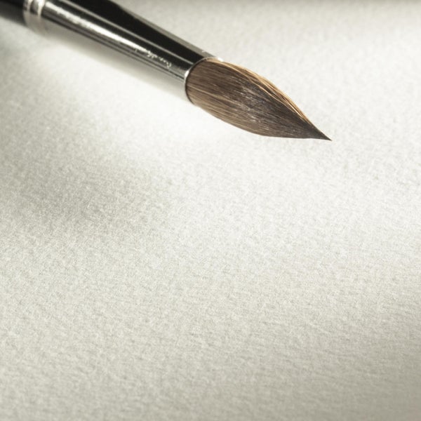 Künstlerpinsel mit feiner Spitze und Metallzwinge auf einer strukturierten Oberfläche.