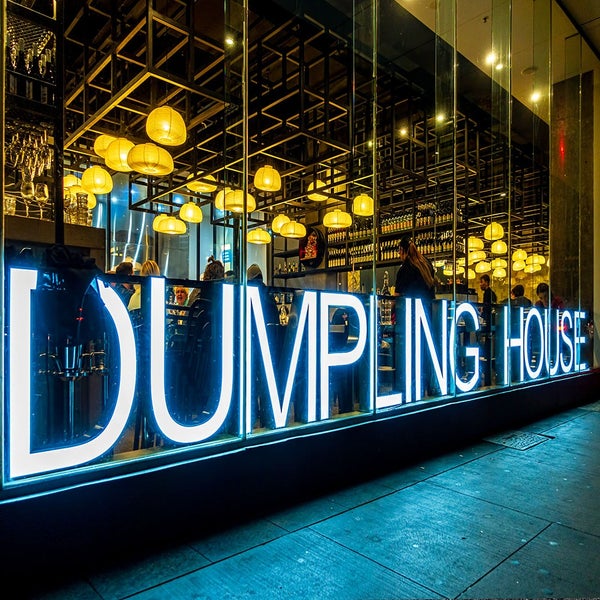 Außenansicht des Restaurants Dumpling House mit Leuchtreklame und Innenbeleuchtung