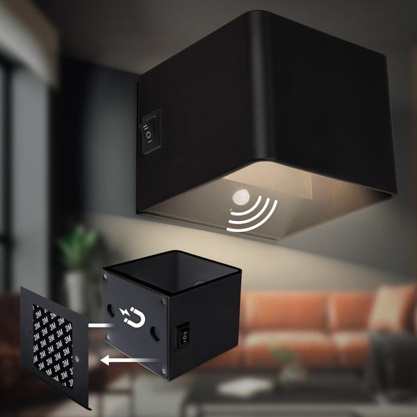 Schwarze würfelförmige LED-Wandleuchte mit Bewegungsmelder, magnetischer Halterung und 3M-Klebeband.