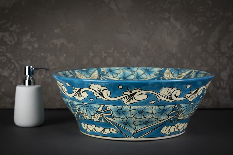 Blaues Aufsatzwaschbecken mit Blumenmuster und Seifenspender