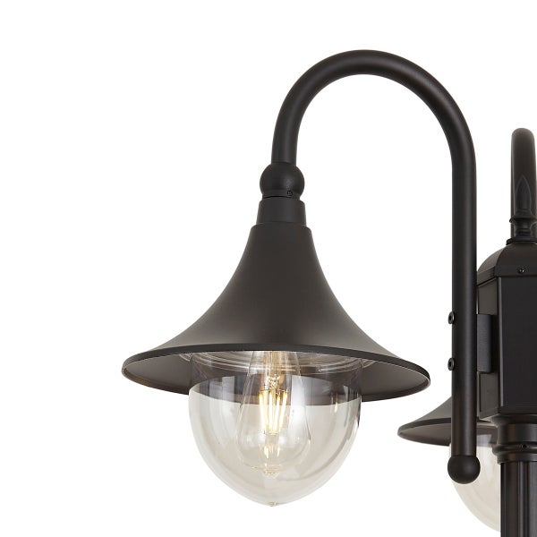 Wandleuchte für den Außenbereich mit klassischem Design, gefertigt aus Metall und Glas, mit gebogenem Arm und glockenförmigem Lampenschirm.