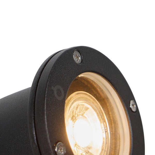 Nahaufnahme eines schwarzen Außenstrahlers mit warmweißer Lichtquelle und sichtbaren Schrauben am Gehäuserand.