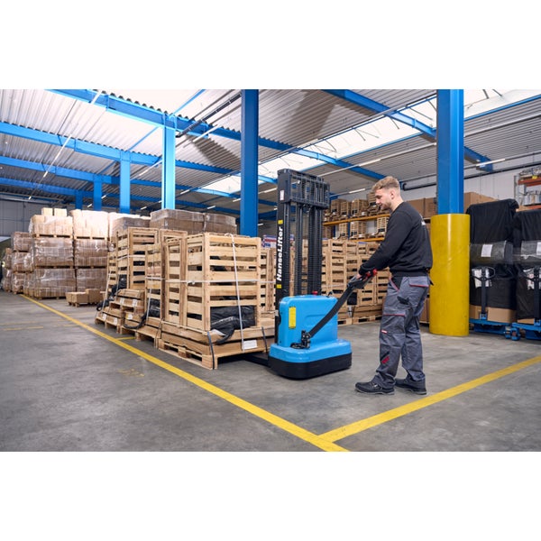 Mitarbeiter bedient einen elektrischen Deichselstapler in einem hellen und organisierten Lagerhaus beim Transport von Holzkisten auf Paletten.