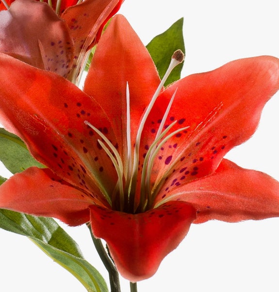 Künstliche Lilie mit roten Blütenblättern, dunklen Punkten und grünen Blättern aus Textilmaterial.