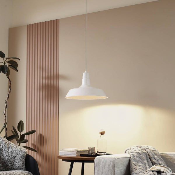 Weiße Hängeleuchte aus Metall im industriellen Stil in einem Wohnzimmer mit Sofa, Beistelltisch aus Holz und Wandpaneelen.